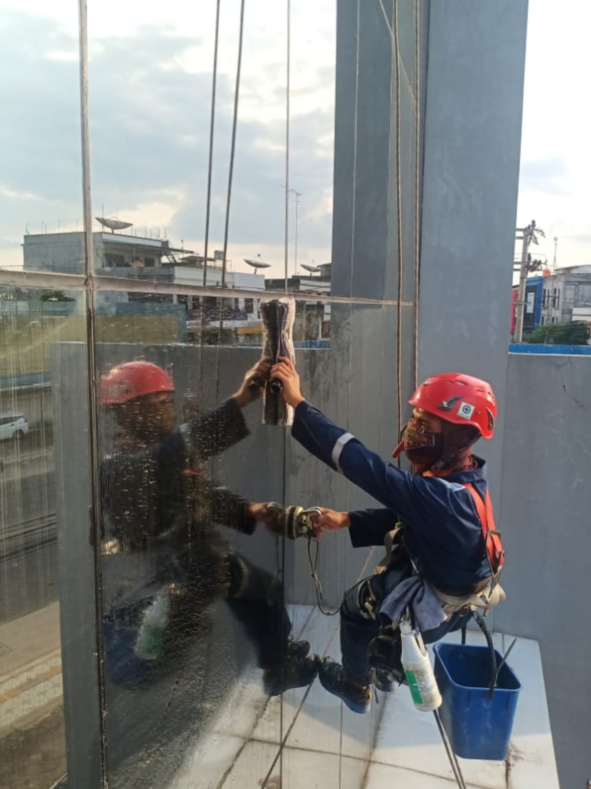 Teknisi Zigzag Navy Indonesia membersihkan kaca dengan Rope Access